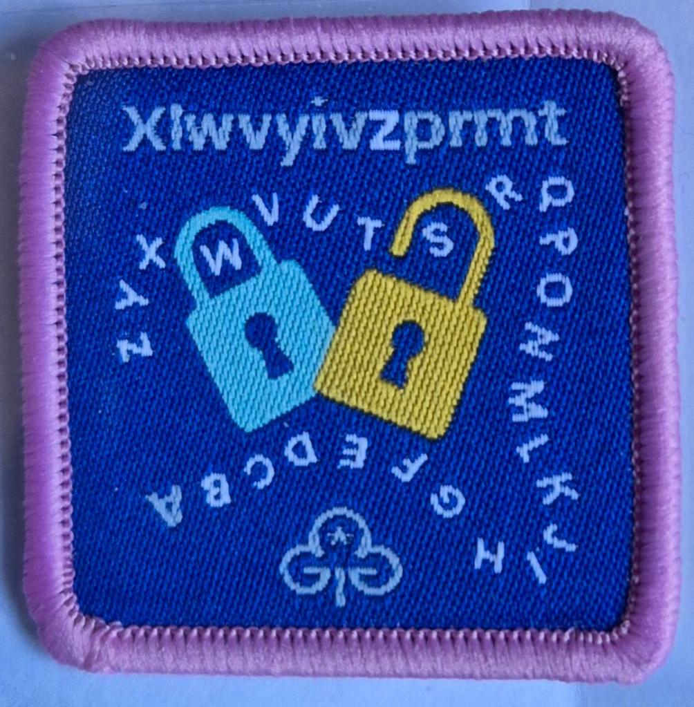 Guide Codebreaking badge, light pink binding.  Padlocks and letter code logo.