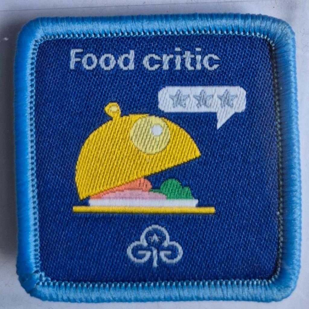 Guide Food Critic badge, blue binding.  Cloched plate logo.