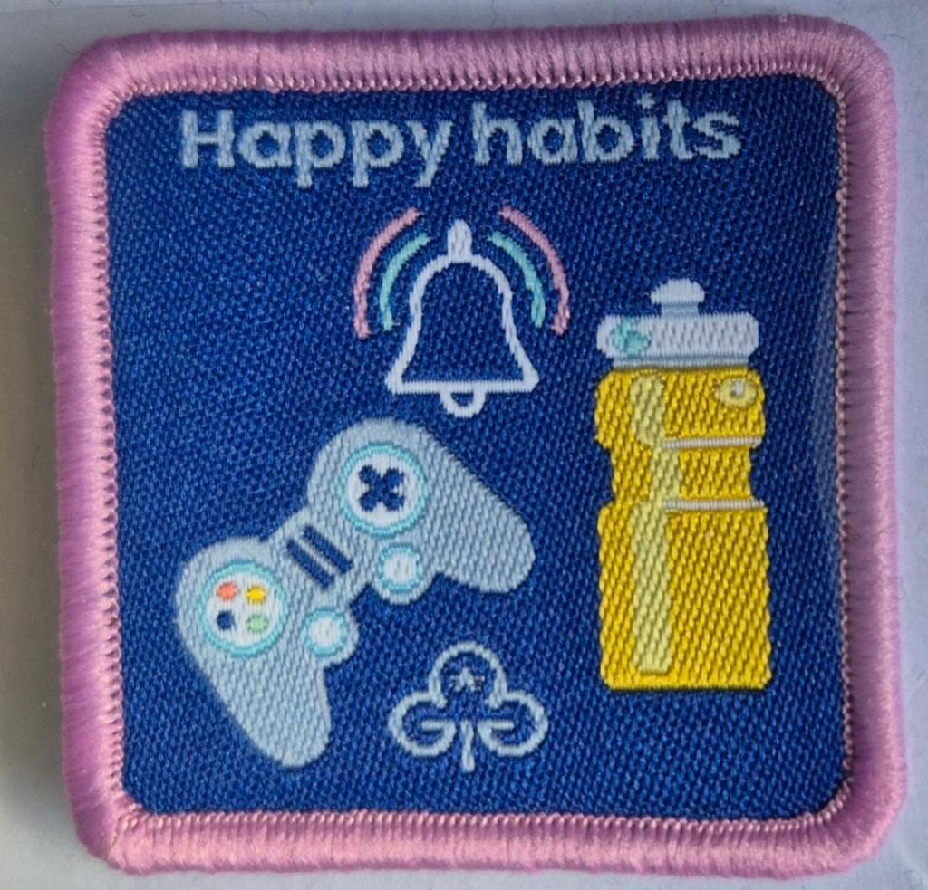 Guide Happy Habits badge, light pink binding.  Game controller and water bottle logo.
