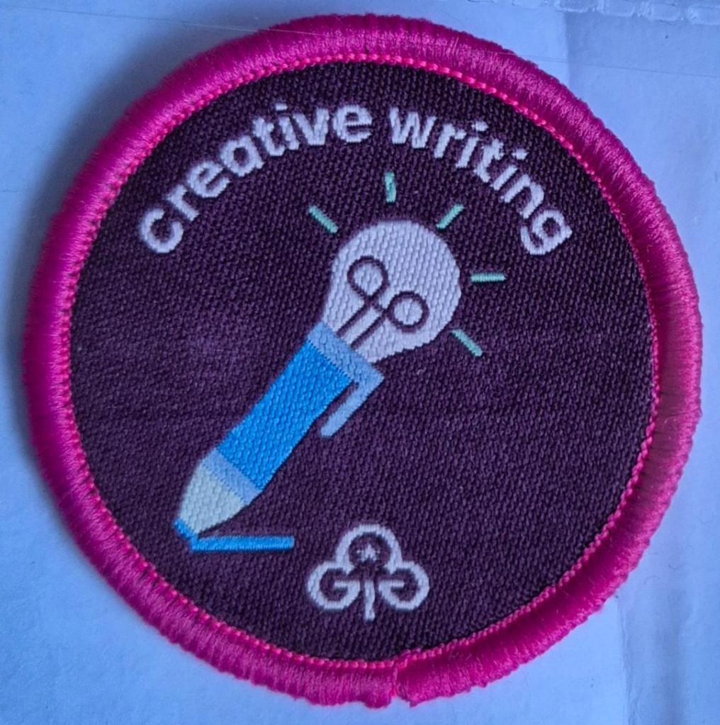 Ranger Creative Writing badge, dark pink binding.  Pen with light bulb logo.